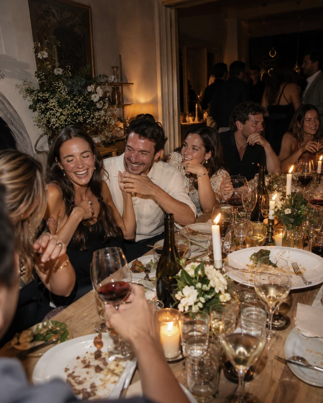 Friends sharing dinner around a candlelit table